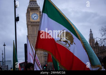 London, Großbritannien. Februar 2024. Ein Demonstrant hält während der Anglo-iranischen Gemeinde eine große iranische Flagge, um den Druck des iranischen Volkes auf eine neue Revolution zu unterstützen. Die anglo-iranische Gemeinschaft gedachte zusammen mit den Anhängern des Nationalen Widerstandsrates des Iran (NCRI) den 45. Jahrestag der demokratischen Revolution im Iran, die das theokratische Regime 1979 unterdrückte. Quelle: SOPA Images Limited/Alamy Live News Stockfoto