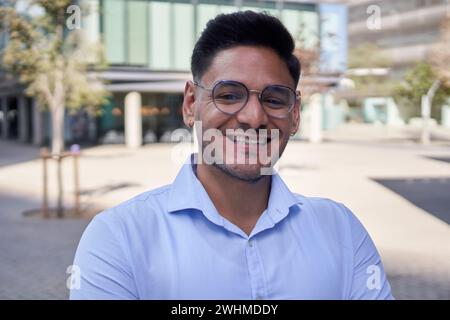 Porträt junger Erwachsener lateinamerikanischer Geschäftsmann oder kommerzielles Außenbüro, das glücklich vor der Kamera schaut. Stockfoto