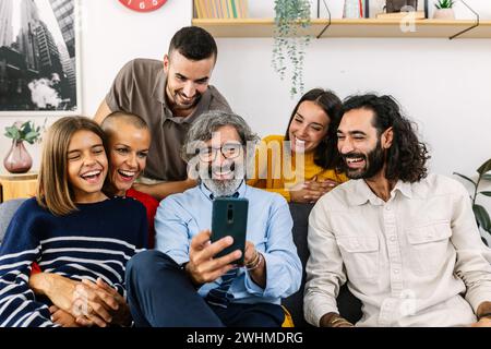 Familie mit mehreren Generationen, die zu Hause zusammen auf dem Sofa sitzen Stockfoto