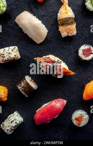 Sushi-Sorte, von oben geschossen. Rollen, Maki, Nigiri auf Schwarz Stockfoto