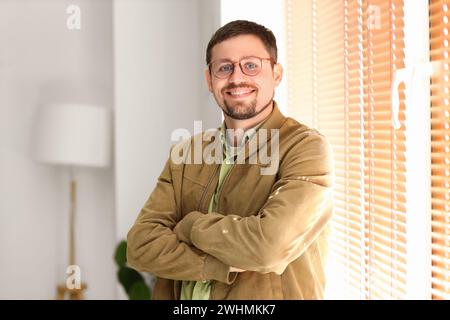 Schöner Mann in stilvoller Brille zu Hause Stockfoto