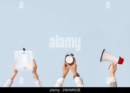 Zeiger, die Stimmzettel, Wecker und Megaphon auf hellem Hintergrund halten. Wahlkonzept Stockfoto