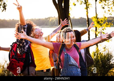 Gruppe von fröhlichen jungen Freunden mit mehreren Rassen, die gemeinsam Spaß haben und Sommerurlaub am Waldsee genießen, konzentrieren Sie sich auf den jungen BH Stockfoto