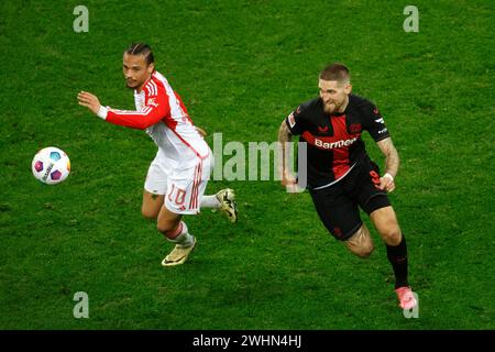 Leverkusen, Deutschland 1. Fussball-Bundesliga, 21. Spieltag, Spieltag 21 Bayer 04 Leverkusen : FC Bayern München 3-0 10. 02. 2024 in der Bay-Arena in Leverkusen Leroy SANE (FCB) li.- und Robert ANDRICH (LEV) re.- Foto: Norbert Schmidt, Düsseldorf Stockfoto