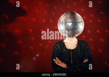 Frau im Paillettenkleid mit Disco-Ball statt Kopf Stockfoto