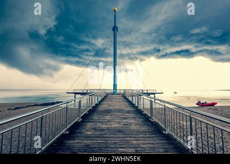 Seebrücke Hohwachter Flunder in Hohwacht, Ostsee, Schleswig-Holstein auf bewölktem, Sturmhimmel Stockfoto