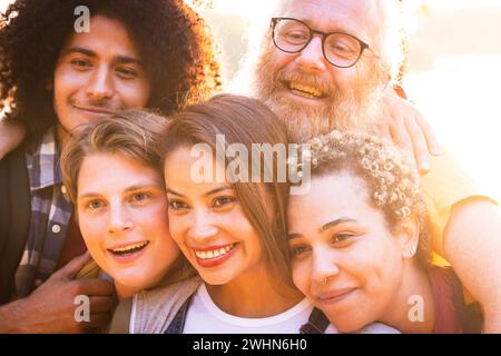 Junge multirassische Gruppe von Freunden verschiedener Geschlechter und Alters, die Spaß haben, ein Selfie mit Smartphone machen und Spaß haben Stockfoto