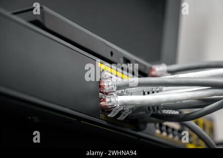 Netzwerk Gigabit Smart PoE Switch mit angeschlossenen Netzwerkkabeln wird am Schreibtisch getestet Stockfoto