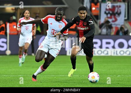 Leverkusen, Deutschland. Februar 2024. Amine Adli (R) von Bayer 04 Leverkusen streitet mit Dayot Upamecano von Bayern München während des ersten Ligaspiels in Leverkusen, Deutschland, 10. Februar 2024. Quelle: Ulrich Hufnagel/Xinhua/Alamy Live News Stockfoto