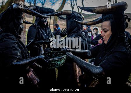 Madrid, Spanien. Februar 2024. Eine Gruppe von Frauen färbt ihre Gesichter während der Luzon-Feierlichkeiten schwarz. Wieder einmal hat die Stadt Luzon, in der Nähe von Guadalajara in Castilla la Mancha, Spanien, ihr traditionelles fest der Teufel von Luzon gefeiert, bei dem einige Einheimische ihre Gesichter malen und sich schwarz kleiden und Hörner und Kuhglocken tragen, während andere ihre Gesichter mit weißen Geschlechtsmasken bedecken. Das Festival ist mehr als 50 Jahre alt. Quelle: SOPA Images Limited/Alamy Live News Stockfoto