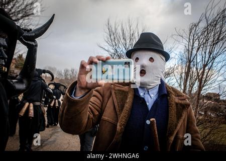 Ein Mann, der an den Luzon-Feierlichkeiten teilnimmt, macht ein Foto mit seinem Handy und bedeckt sein Gesicht mit einem weißen Schal, der sich selbst als die „Mascaritas“ der Luzon-Feierlichkeiten bezeichnet. Wieder einmal hat die Stadt Luzon, in der Nähe von Guadalajara in Castilla la Mancha, Spanien, ihr traditionelles fest der Teufel von Luzon gefeiert, bei dem einige Einheimische ihre Gesichter malen und sich schwarz kleiden und Hörner und Kuhglocken tragen, während andere ihre Gesichter mit weißen Geschlechtsmasken bedecken. Das Festival ist mehr als 50 Jahre alt. (Foto: David Canales/SOPA Images/SIPA USA) Stockfoto