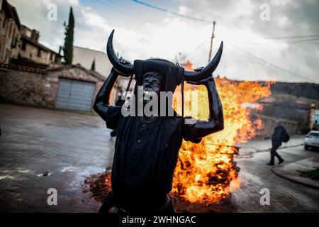 Madrid, Spanien. Februar 2024. Ein Mann, der von Hörnern und schwarzer Farbe auf seinem Körper charakterisiert ist, nimmt an Luzon-Festlichkeiten Teil. Wieder einmal hat die Stadt Luzon, in der Nähe von Guadalajara in Castilla la Mancha, Spanien, ihr traditionelles fest der Teufel von Luzon gefeiert, bei dem einige Einheimische ihre Gesichter malen und sich schwarz kleiden und Hörner und Kuhglocken tragen, während andere ihre Gesichter mit weißen Geschlechtsmasken bedecken. Das Festival ist mehr als 50 Jahre alt. (Foto: David Canales/SOPA Images/SIPA USA) Credit: SIPA USA/Alamy Live News Stockfoto