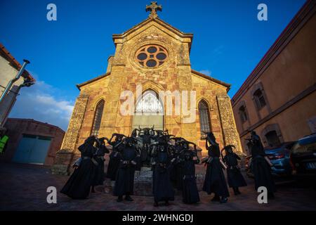 Madrid, Spanien. Februar 2024. Die Teilnehmer nehmen an den Festlichkeiten der Stadt Luzon vor einer Kapelle Teil. Wieder einmal hat die Stadt Luzon, in der Nähe von Guadalajara in Castilla la Mancha, Spanien, ihr traditionelles fest der Teufel von Luzon gefeiert, bei dem einige Einheimische ihre Gesichter malen und sich schwarz kleiden und Hörner und Kuhglocken tragen, während andere ihre Gesichter mit weißen Geschlechtsmasken bedecken. Das Festival ist mehr als 50 Jahre alt. Quelle: SOPA Images Limited/Alamy Live News Stockfoto