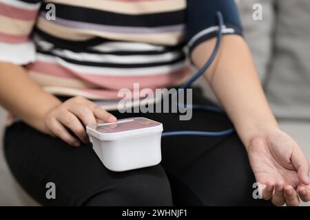 Übergewichtige Frauen plus Größe Selbstkontrollen Blutdruck und Herzfrequenztonometer Selbstkontrolle zu Hause Stockfoto