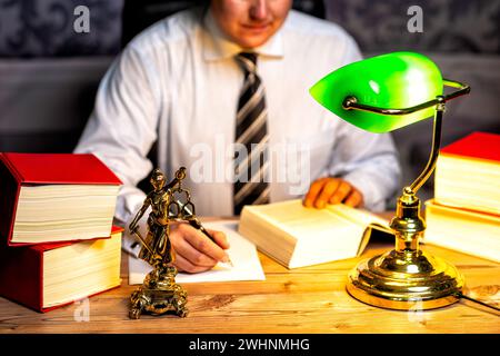 Büro eines Anwalts mit Statue von Lady Justice, Göttin Justitia, auf dem Schreibtisch Stockfoto