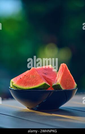 Wassermelonenscheiben in schwarzer Schüssel auf dem Tisch Stockfoto