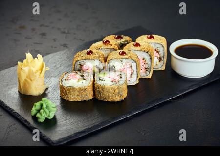 Tempura heiße Sushi-Rollen mit Krabben auf dunklem Hintergrund. Sushi-Menü. Japanisches Essen. Stockfoto