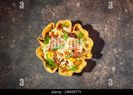 Taco-Salat in Tortilla-Schüssel mit Rind, Käse, Mais und Salat Stockfoto