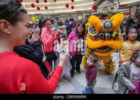 Richmond, Kanada. Februar 2024. Die Leute posieren für Fotos mit einem Löwentanzkünstler in einem Einkaufszentrum, um das chinesische Neujahrsfest am 10. Februar 2024 in Richmond, British Columbia, Kanada, zu feiern. Quelle: Liang Sen/Xinhua/Alamy Live News Stockfoto