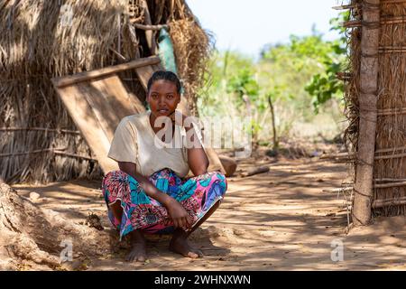 Madagassische Frau vor ihrer Hütte, die in der Schattenwitze ruht. Belo Sur Tsiribihina, Madagaskar Stockfoto