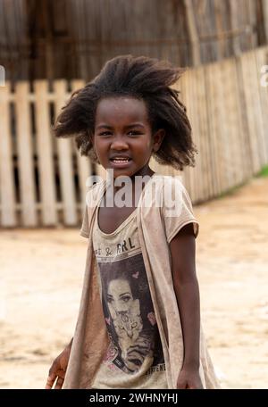 Kleines süßes madagassisches Mädchen mit langen Haaren, kleine Tänzerin bei der Feier im Dorf Bekopaka, Region Melaky, Madagaskar. Stockfoto