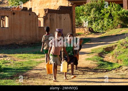 Morgenritual im Dorf Lakanga, während madagassische Mädchen Wasser zum Kochen holen. Andringitra Berg, Madagaskar Stockfoto