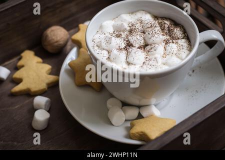 Eine Tasse Kakao mit Marshmallow und Keksen in Tablettennähe. Selektiver Fokus. Weihnachtliche Einrichtung Stockfoto