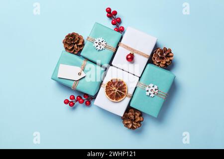 Geschenkkartons in Papier verpackt, mit Kugeln und Garn verziert. Geschenkverpackung Für Umweltfreundliche Weihnachtsgeschenke Stockfoto