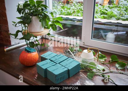 Meisterkurs über die Herstellung von Blumensträußen. Herbststrauß in einem Kürbis. Blumenarrangements, die schöne Sträuße mit Ihrem eigenen han kreieren Stockfoto