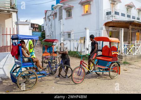 Traditionelle Rikscha auf den Straßen der Stadt. Rikschas sind ein gängiges Transportmittel in Madagaskar. Stockfoto