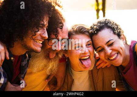 Fröhliche junge Gruppe von besten Freunden aus verschiedenen Rassen, die sich im Freien amüsieren. Millennial vielfältige Menschen, die die gemeinsame Zeit genießen, Tak Stockfoto