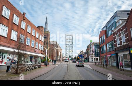 Hauptstraße mit entfernter Hebebrücke über den kanalisierten Fluss Gouwe im Dorf Boskoop, Niederlande. Stockfoto