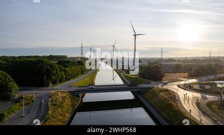 Windkraftanlagen, die bei Sonnenuntergang grüne Energie erzeugen, von oben gesehen in Halle, Vlaams Brabant, Belgien, neben dem Kanal Bruss Stockfoto