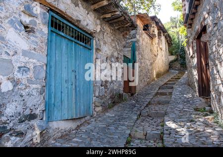 Steiniger Fußweg durch ein traditionelles Dorf. Steinige Häuser mit Holztüren. Vintage-Architektur Stockfoto