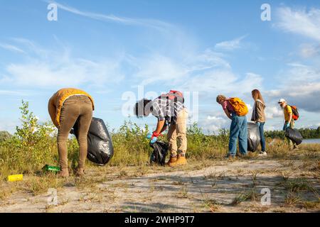 Verschiedene Freunde, die das Ufer des Sees reinigen Stockfoto