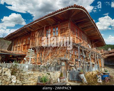 Knysna, Bulgarien - engen, gepflasterten Straßen und rustikalen traditionelle Häuser aus Stein und Holz mit bigroot cranesbill (Geranium macrorrhizum) zusammen. Stockfoto