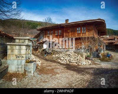 Knysna, Bulgarien - engen, gepflasterten Straßen und rustikalen traditionelle Häuser aus Stein und Holz mit bigroot cranesbill (Geranium macrorrhizum) zusammen. Stockfoto