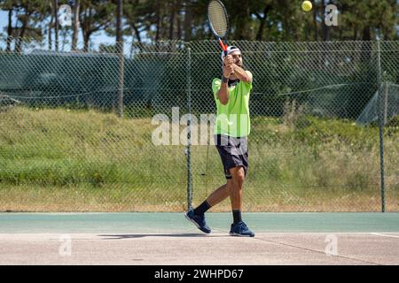 Tennisspieler schlägt beim Ball die Rückhand Stockfoto