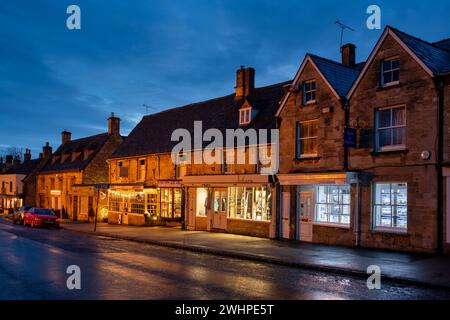 Geschäfte entlang der High Street in Burford bei Sonnenaufgang. Cotswolds, Oxfordshire, England Stockfoto