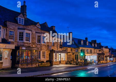 Geschäfte entlang der High Street in Burford bei Sonnenaufgang. Cotswolds, Oxfordshire, England Stockfoto