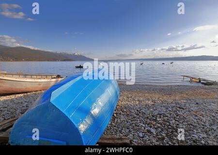 330 einheimische Ruderboote auf dem Ufer, Kieselstrand Saraiste am See entlang der Kosta Abrash Straße. Ohrid-Nordmazedonien. Stockfoto