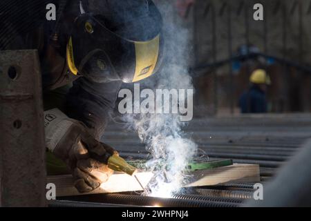 Schweißen des Arbeitnehmers in Schutzkleidung Stockfoto