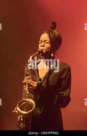 Vertikales Porträt einer afroamerikanischen jungen Frau, die Saxophon spielt, während sie Jazzmusik auf der Bühne im Club aufführt Stockfoto