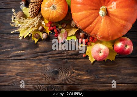 Herbsttag Thanksgiving oder Halloween Hintergrund. Festliche Herbstdekoration aus Reifen Kürbissen, Beeren und Blättern auf einem Holzhintergrund Stockfoto