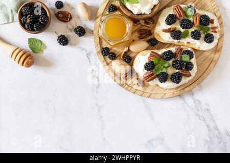 Gesunde Frühstückstoasts. Keto Diet Sandwiches. Keto-Snack. Süße Bruschetta mit Käse und Beeren, brombeerricotta und Hone Stockfoto