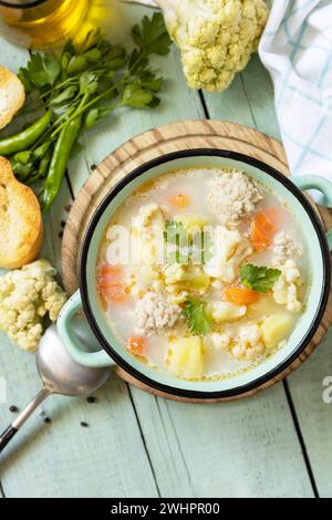 Low Carb gesunde Ernährung. Blumenkohlsuppe mit Hähnchenfleisch und Gemüse auf einem rustikalen Holztisch. Blick von oben. Kopieren Stockfoto