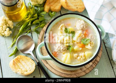 Blumenkohlsuppe mit Hähnchenfleischbällchen und Gemüse auf einem rustikalen Holztisch. Kohlenhydratarme gesunde Ernährung. Stockfoto