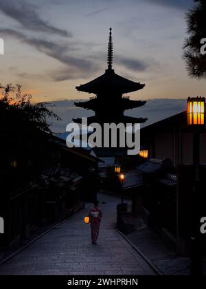 Asiatische Reisende, die traditionelle japanische Kimonos tragen und eine Laterne halten, spazieren durch den Bezirk Higashiyama bei Sonnenuntergang am 29. August 2022 in Kyoto, Japan. Higashiyama-ku bewahrt das Aussehen und die Atmosphäre des Feudalzeitalters Japans in einem holzgebauten historischen Viertel mit engen Gassen, gesäumt von traditionellen Töpfereien, Teehäusern und Restaurants. Foto von Victor Fraile / Power Sport Images Stockfoto