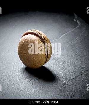 Schokoladen-Macaron auf schwarzem Hintergrund Stockfoto