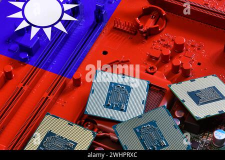 Flagge Taiwans auf einem rot lackierten PC-Mainboard mit einigen Prozessoren. Konzept der Vorherrschaft in der globalen Mikrochip- und Halbleiterfertigung. Stockfoto